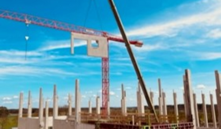 Kran hebt Betonfertigteil am FEGA & Schmitt Neubau
